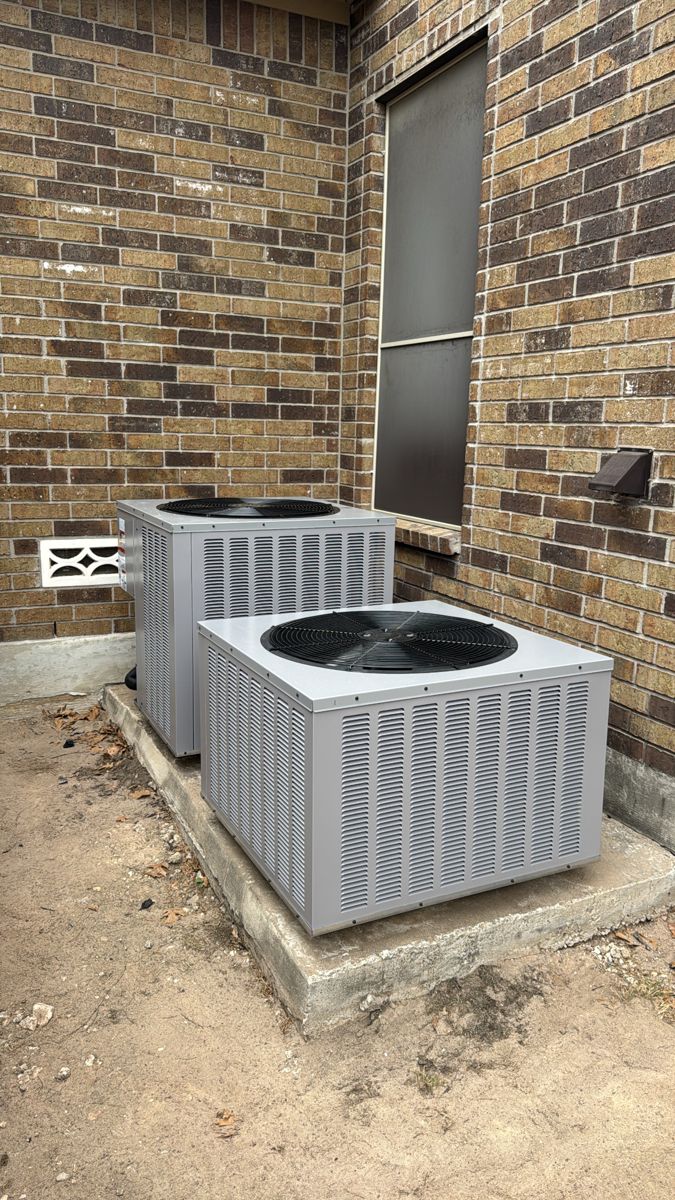 Two new AC condenser units installed side by side at a San Antonio area home